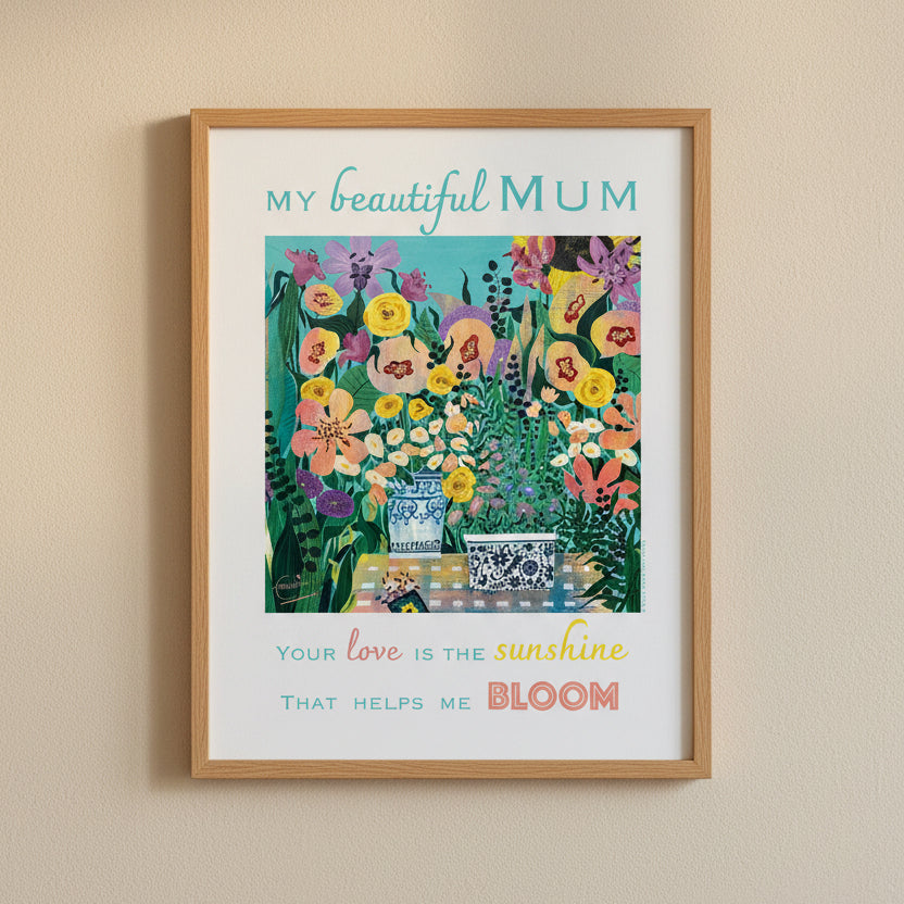 An art print with the text 'MY beautiful MUM' at the top and 'Your love is the sunshine that helps me BLOOM' at the bottom, surrounding a colourful floral illustration with a blue-and-white vase and patterned boxes.