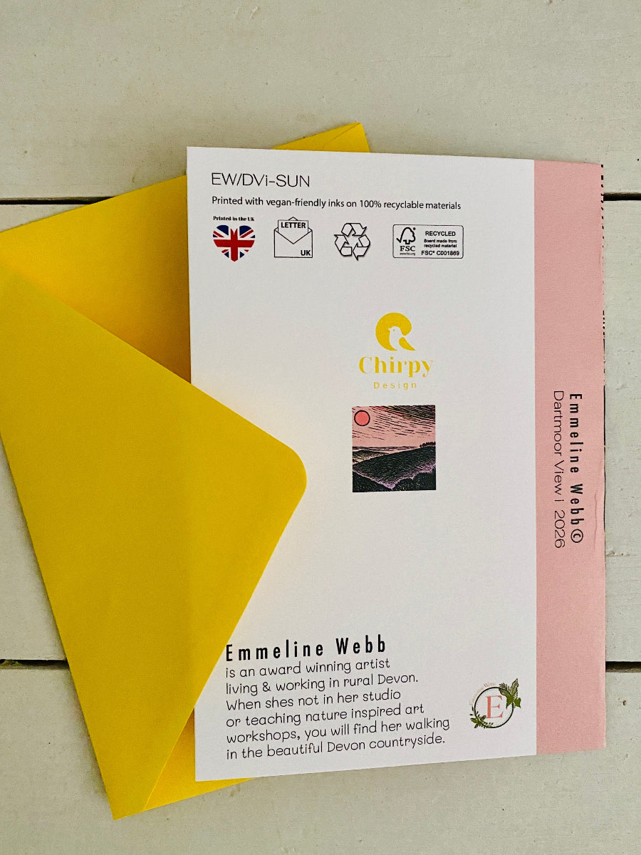 A printed art print card with a pink side border and yellow envelope behind it, photographed on a light wood surface. The card includes the Chippy Design logo, artist text for Emmeline Webb, and a small landscape photo.