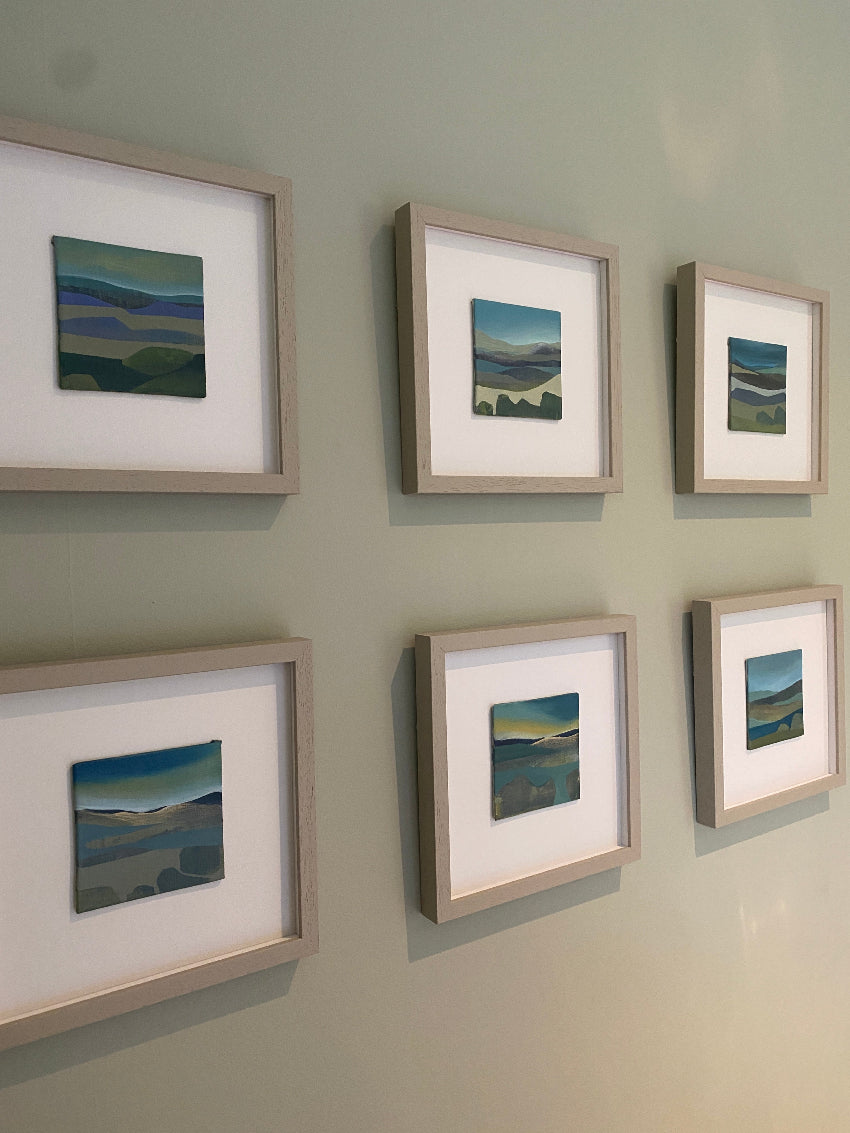 Six framed artworks on a wall
