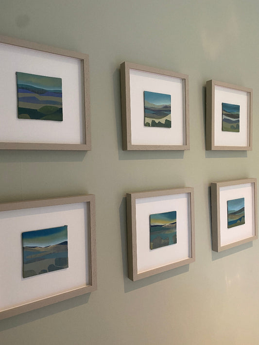 Six framed artworks on a wall