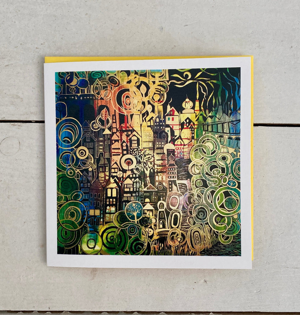 A square art print card featuring an abstract, colourful illustration with swirling patterns and stylised architectural forms, photographed flat on a light grey wood surface.