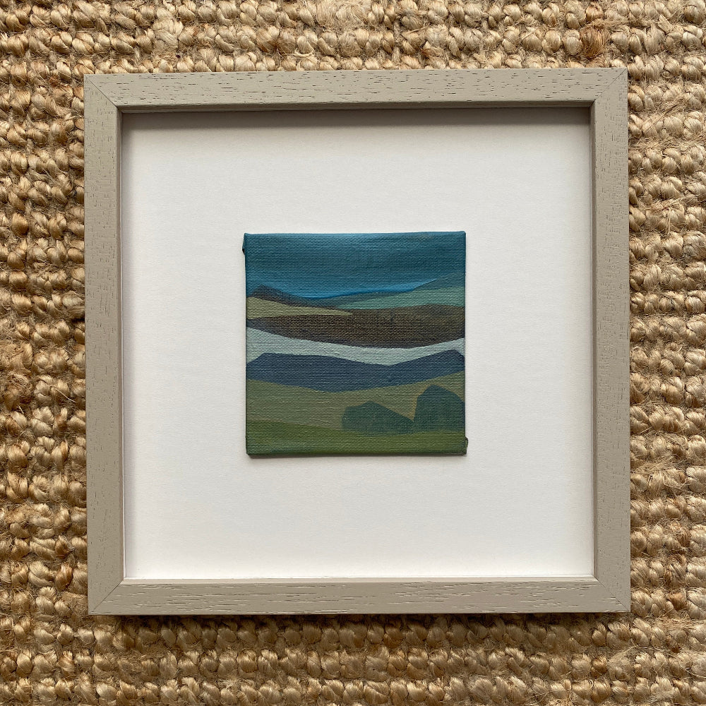 Framed artwork of an abstract  landscape on a textured wall