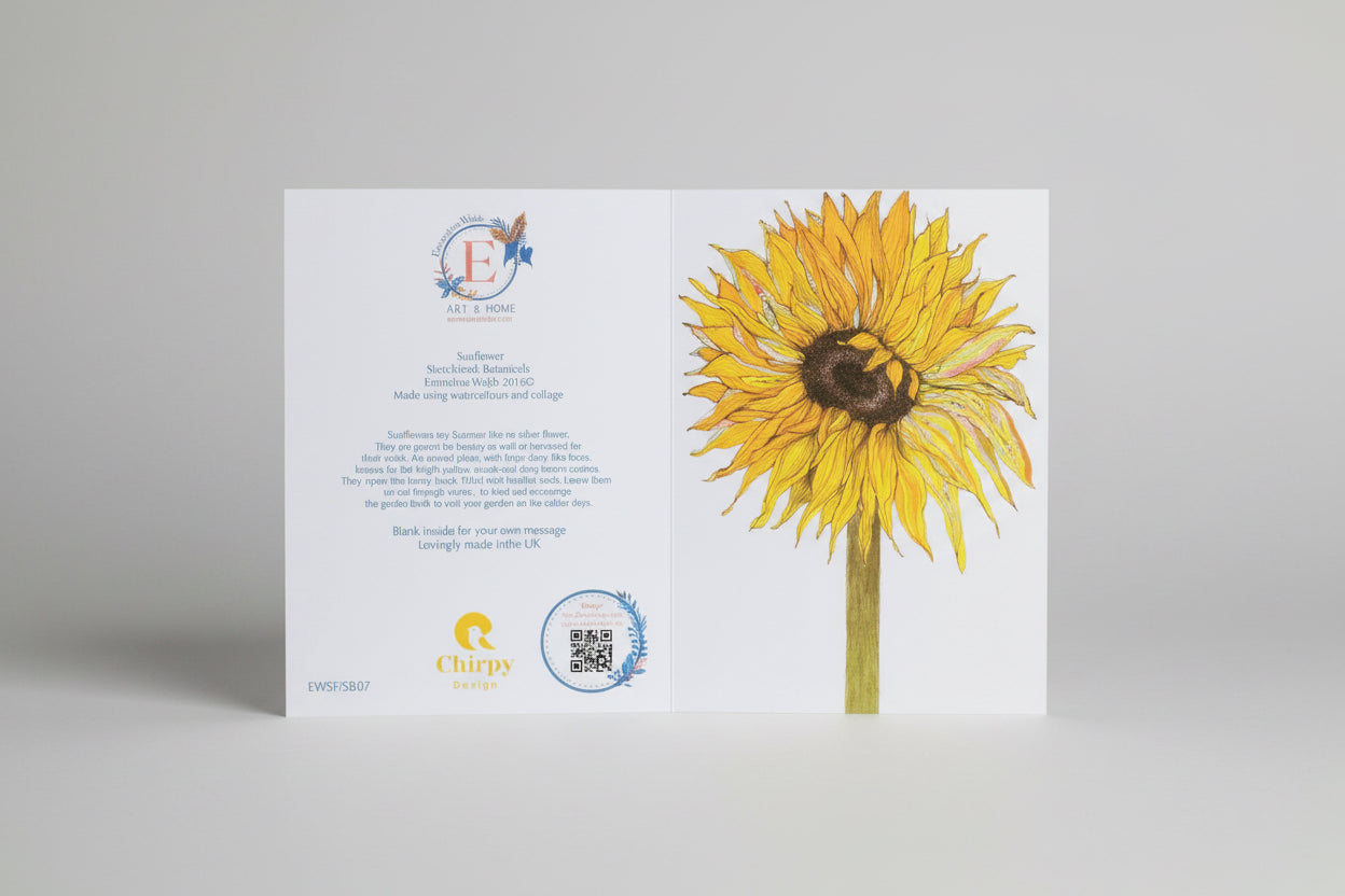 An un-folded white card featuring a large illustrated sunflower on the right panel and printed text/logo on the left panel, photographed against a light neutral background.