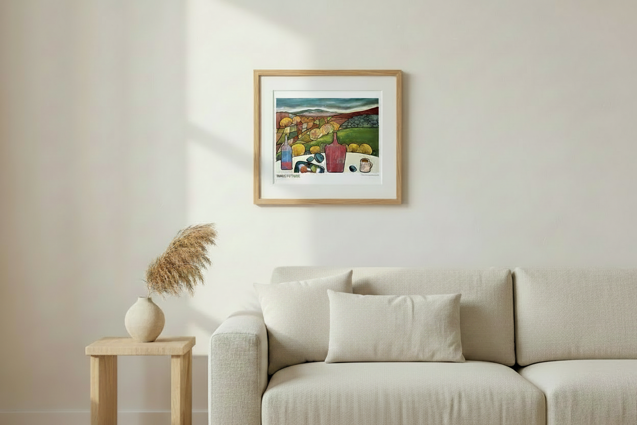 A framed art print titled 'TABLE TO TORS' featuring a colorful still life illustration of lemons, bottles, and fruit on a table, displayed on a light beige wall.